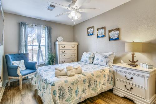 um quarto com uma cama e uma cadeira azul em Always 5 O'clock em Galveston