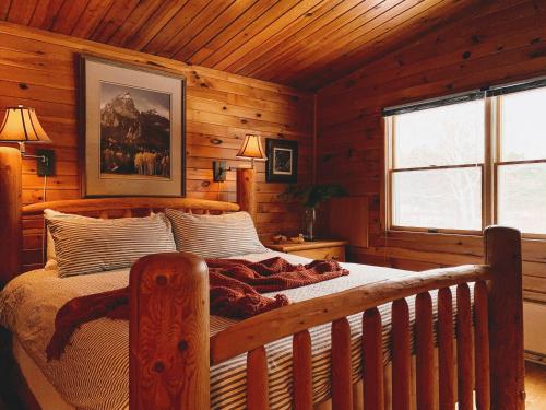 a bedroom with a bed in a log cabin at NewVida Preserve in Wilmington