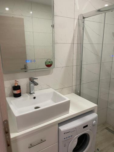 a bathroom with a sink and a washing machine at Neraida Central Apartment in Loutraki