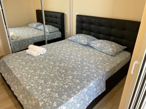 sypialnia z dwoma łóżkami i lustrem w obiekcie Neraida Central Apartment w mieście Lutraki