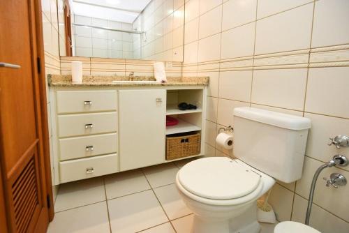 La salle de bains est pourvue de toilettes blanches et d'un lavabo. dans l'établissement Rosa Edifício Bavária, à Gramado