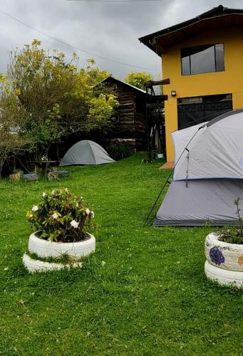 a couple of tents and some plants in a yard at Iwoka Ecoturismo in La Calera