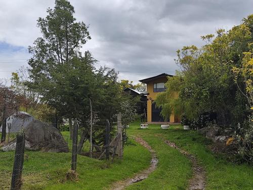 un patio con una valla y una casa en Iwoka Ecoturismo, en La Calera