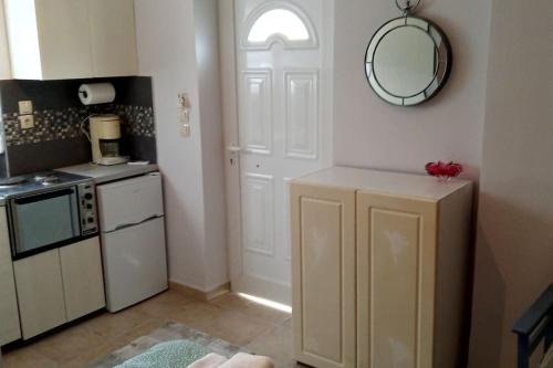 uma cozinha com uma porta branca e um espelho em Paris house 4 em Patra