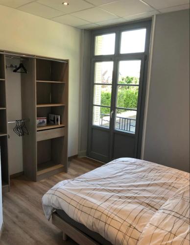 a bedroom with a bed and a large window at Résidence Harmonie Appartement N 4 meublé Avec Petit Déjeuner in Néris-les-Bains