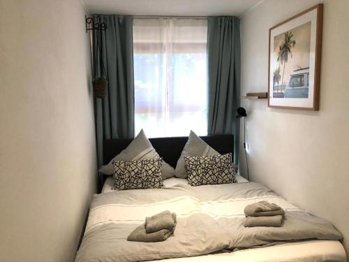 a bedroom with a bed with pillows and a window at Sky & Sand SPO Nordsee by Nature I Boxspringbett, Terrasse, Zentral, Nah am Deich in Ording