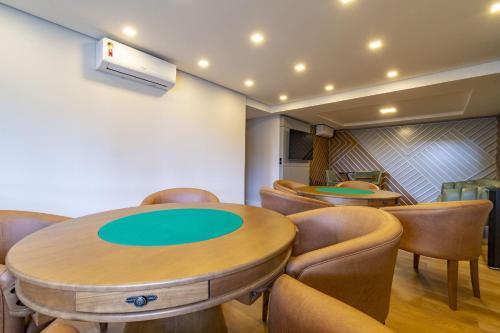 una sala de conferencias con mesa y sillas en Rosa Edifício Bellagio Canela com Infraestrutura completa, en Canela