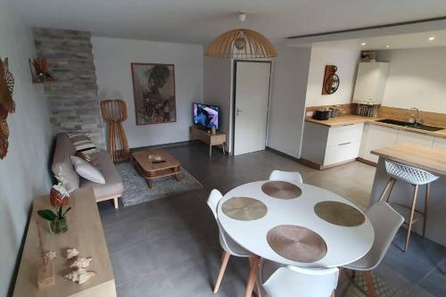 a living room with a table and a kitchen at Logement entier de plain-pied in Épagny