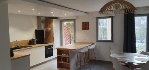 uma cozinha com um balcão e uma mesa e uma sala de jantar em Logement entier de plain-pied em Épagny
