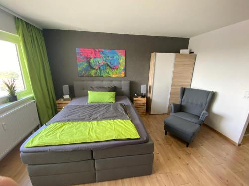 um quarto com uma cama e uma cadeira em Apartment Stadtblick em Braunschweig
