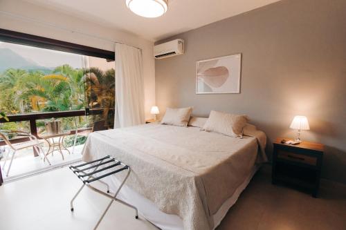 a bedroom with a bed and a large window at Angra Boutique Hotel in Angra dos Reis