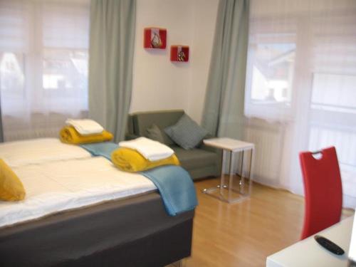 1 dormitorio con cama con almohadas amarillas y sofá en Diamond house deluxe 6 Koblenz, en Coblenza