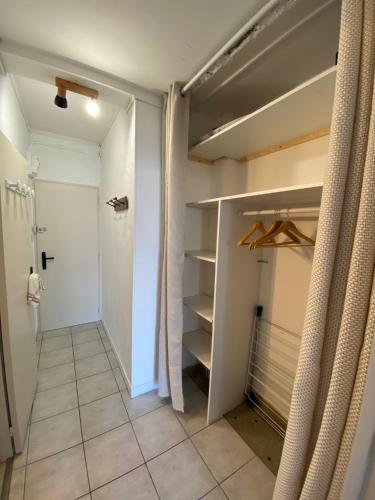 - un dressing avec une porte et des étagères dans l'établissement SUPERBE STUDIO A SAINT JEAN DE MONTS, à Saint-Jean-de-Monts