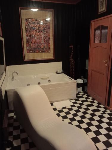 a bath tub in a bathroom with a checkered floor at Tu Mansión in Navalcarnero