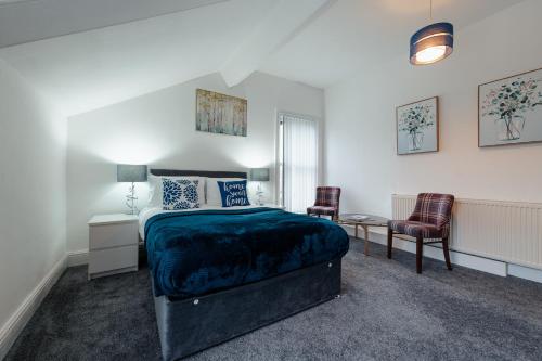 a bedroom with a bed and a table and two chairs at Crosby Apartments in Liverpool