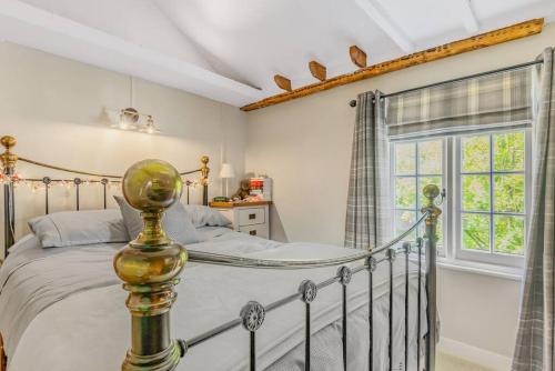 una camera da letto con un letto e una finestra di Pieman's Cottage - Pulborough, West Sussex Cottage - sunny courtyard a Pulborough