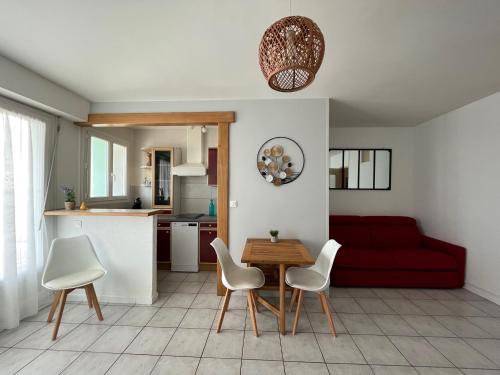 - un salon avec un canapé rouge, une table et des chaises dans l'établissement SUPERBE STUDIO A SAINT JEAN DE MONTS, à Saint-Jean-de-Monts