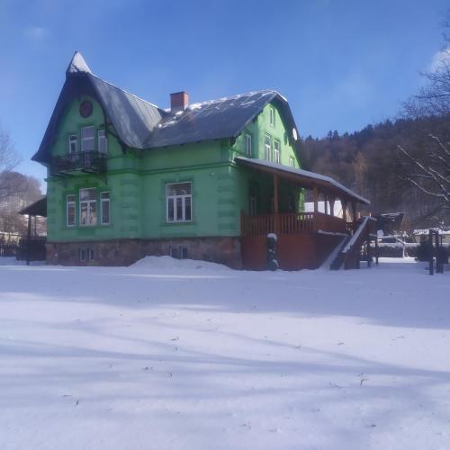 a green house in the snow in front at U Žabky in Horní Maršov