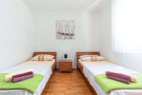 2 aparte bedden in een kamer met witte muren bij kuća za odmor Iris in Vela Luka