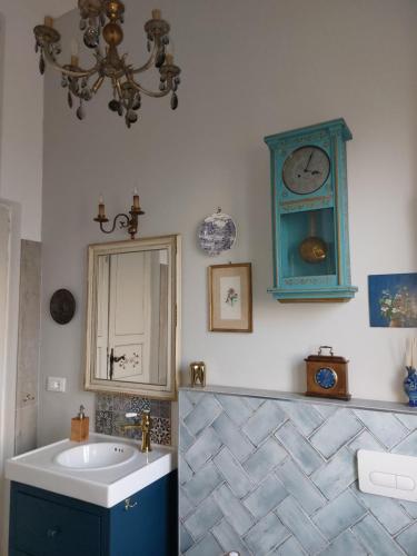 baño con lavabo y reloj azul en la pared en Bed and Breakfast La Pecora Rosa, en SantʼOmero