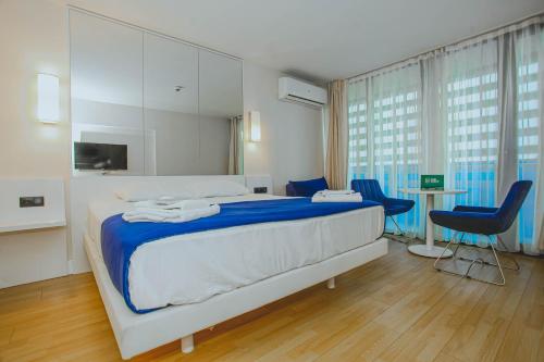 1 dormitorio con 1 cama grande y 2 sillas en Orbi City Sea View - Special Category, en Batumi