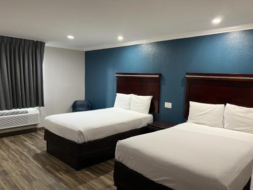 Habitación de hotel con 2 camas y pared azul en Mesa AZ Near Downtown & Sloan Park, en Mesa