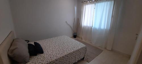 1 dormitorio con cama y ventana en Pousada Graboschii, 300mt da praia do Refúgio, en Aracaju