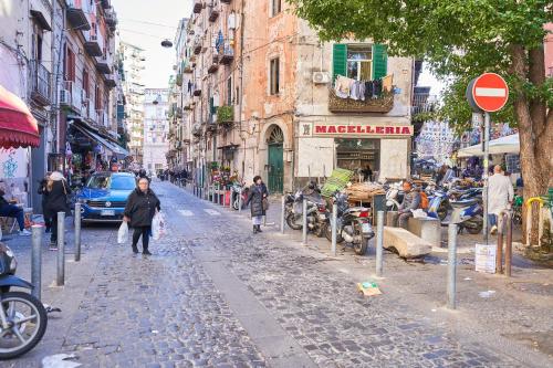 a woman walking down a street in a city at Toto e Peppino Luxury Rooms in Naples