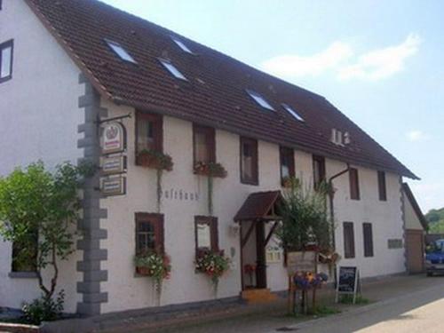 a white building with a black roof and windows at Naturparkhotel & Landgasthof Stromberg in Sachsenheim