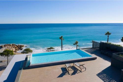 une piscine avec l'océan en arrière-plan dans l'établissement Résidence Pearl Beach - Seaside Rooftop Pool, à Villeneuve-Loubet