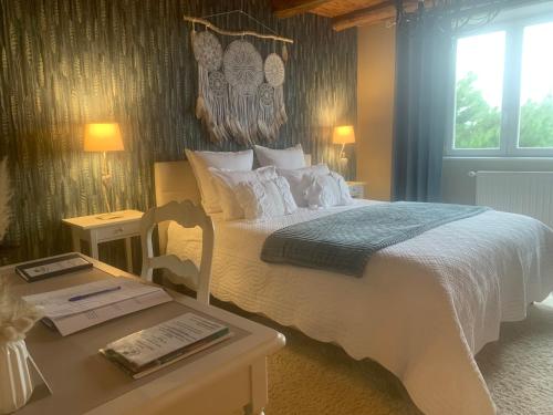 een slaapkamer met een wit bed en een tafel met een sidx sidx bij Maison Mard'Or Chambre Plume in Mardor