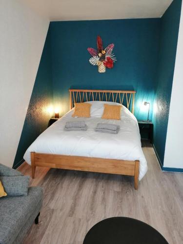 a bedroom with a large bed with a blue wall at Orion - SILS Coquet studio proche des commodités et transports in Hérouville-Saint-Clair