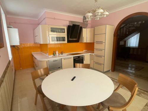 a kitchen with a white table and chairs at Lux House in Chernivtsi