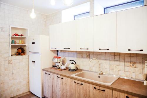 a kitchen with a sink and a white refrigerator at Villa Vinne Cirase in Castiglione dʼOtranto