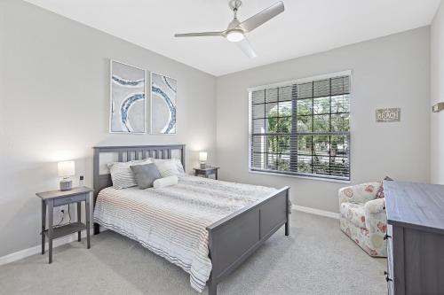 Un dormitorio con una cama y un sofá y una ventana. en Modern waterfront home in Artesia with pool/gym, en Lely Resort