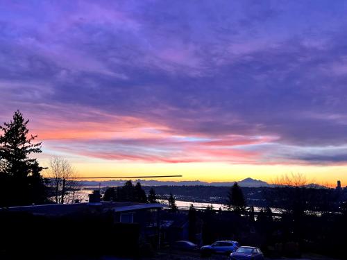 a view of a sunset from the balcony of a house at Lovely J Home -Stunning river view cozy two bedroom private suite in New Westminster