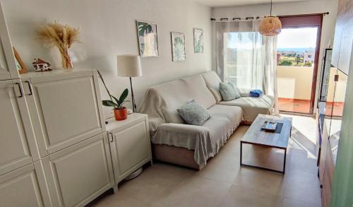 salon z kanapą i stołem w obiekcie Ático de ensueño, El Toyo, Almería - Playas, Golf, Cabo de Gata w mieście Retamar
