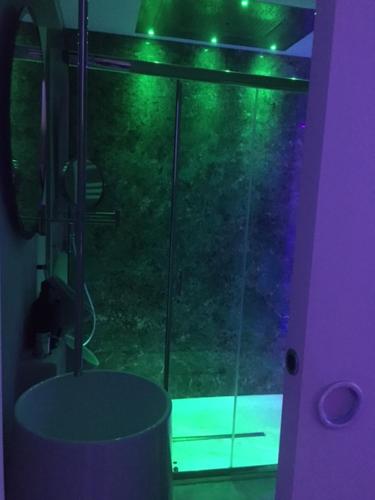 a bathroom with a glass shower with green lights at QUIRICO GUEST HOUSE in Locorotondo