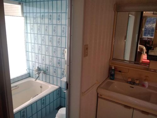 y baño con bañera, lavabo y espejo. en Cafe panorama - Vacation STAY 96734v, en Esumi