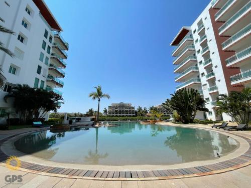 a large swimming pool in the middle of two buildings at Depa en la marina a 5min de la playa by G P S rentas in Mazatlán