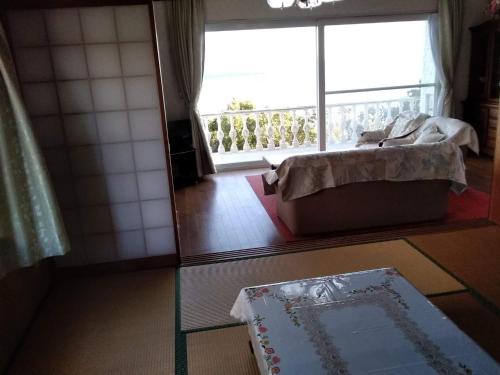 sala de estar con cama y ventana grande en Cafe panorama - Vacation STAY 96734v, en Esumi