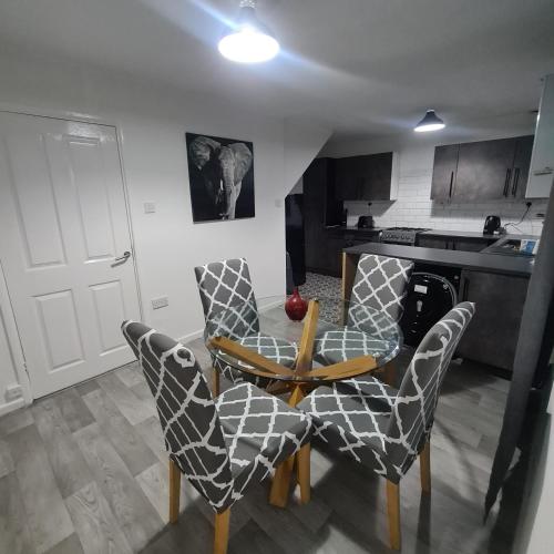 een keuken met een tafel en stoelen in een kamer bij Freshen-Up Stays in Oakengates