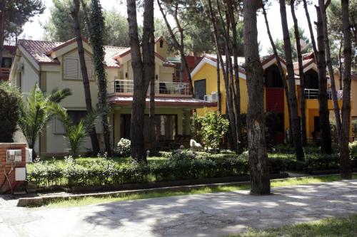 dom z drzewami przed nim w obiekcie Marea Resort w mieście Golem