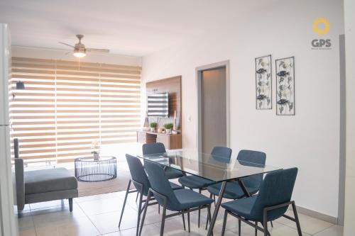 a dining room with a glass table and chairs at Depa en la marina a 5min de la playa by G P S rentas in Mazatlán