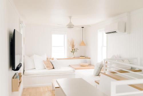 a white living room with a white couch at The Sunsetter by WB Abodes in Wrightsville Beach