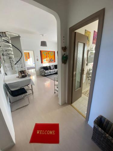 vistas a un pasillo con una señal de bienvenida y una puerta en Appartamento Lella con meravigliosa vista zona Corso Bagni, en Acqui Terme