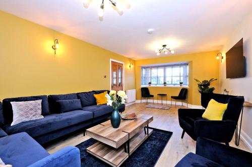 a living room with a blue couch and yellow walls at Rosebrae in Insch