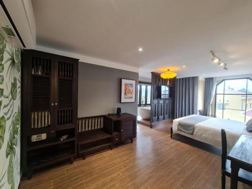 a bedroom with a bed and a desk in a room at Hoianan Boutique Hotel in Hoi An