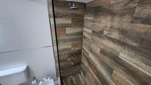 y baño con ducha y pared de madera. en Excelente departamento en la mejor ubicacion de Mendoza en Mendoza