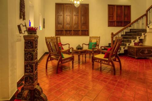 
a living room filled with furniture and a fire place at The Fort Bungalow in Cochin
